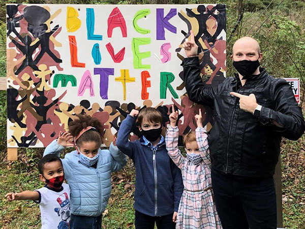 jonathan riedel with sunday school children in front of black lives matter sign
