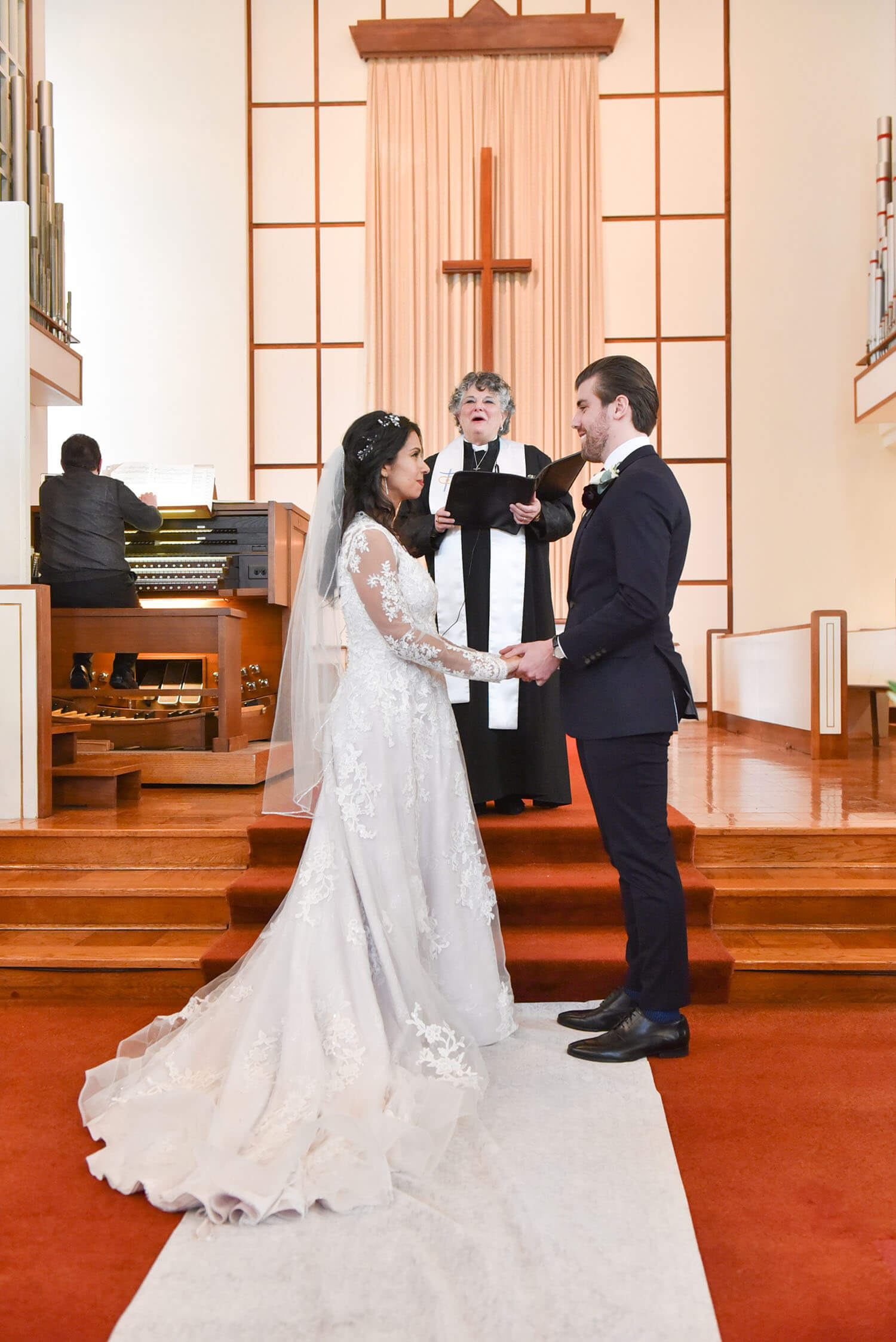 bride and groom in sanctuary with reverend martha